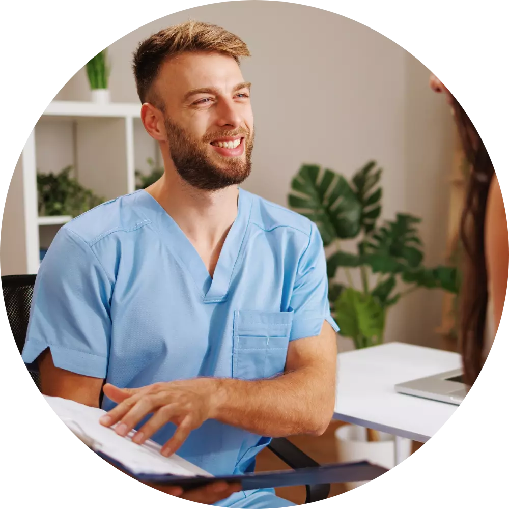 Happy male nurse sitting down talking to participant